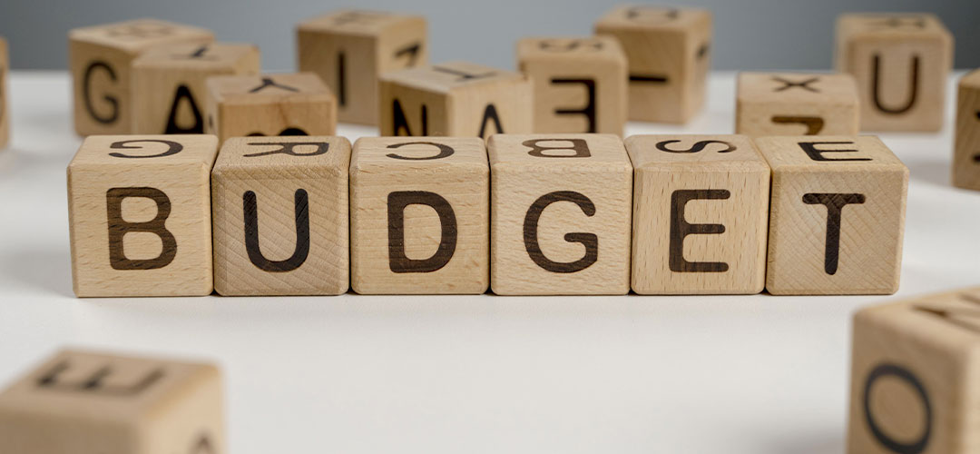 Cubes en bois formant le mot BUDGET sur une surface blanche, illustrant les deux budgets du CSE : budget de fonctionnement et budget des activités sociales